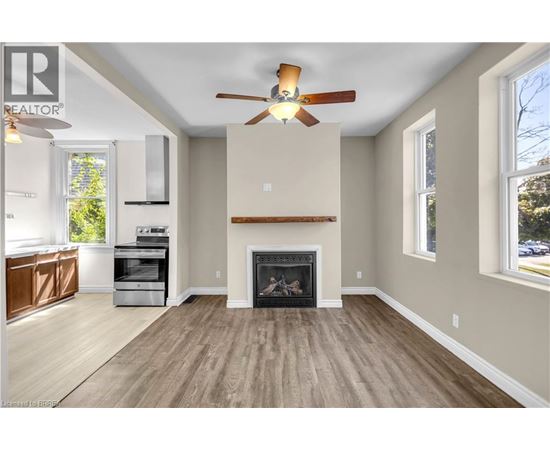 A living room with a fireplace and a ceiling fan.