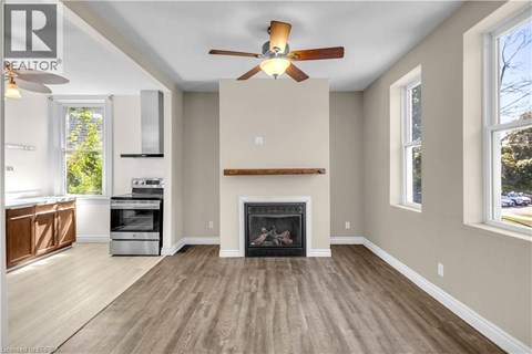 A living room with a fireplace and a ceiling fan.
