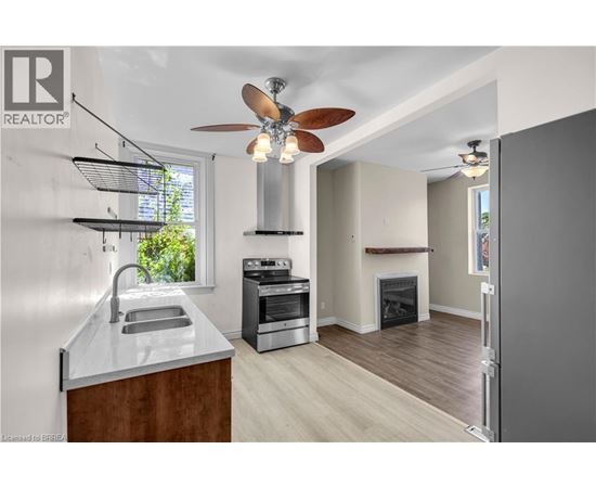 A modern kitchen with a stainless steel oven and a wood-burning stove.