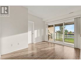 A spacious room with a sliding glass door leading to a balcony.
