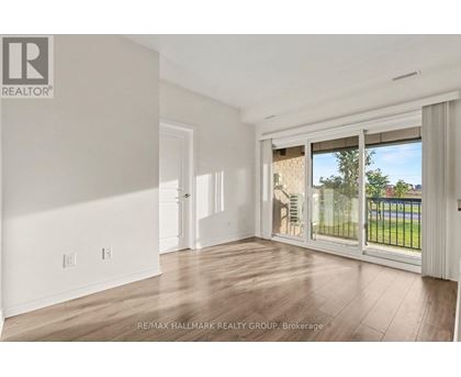 A spacious room with a sliding glass door leading to a balcony.