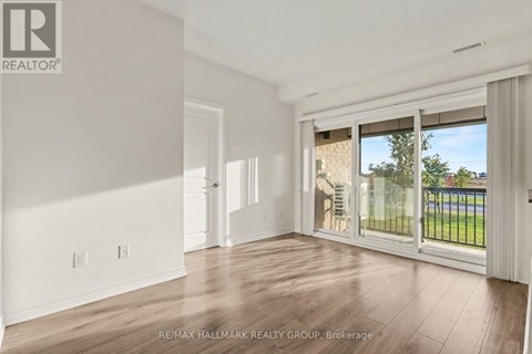 A spacious room with a sliding glass door leading to a balcony.