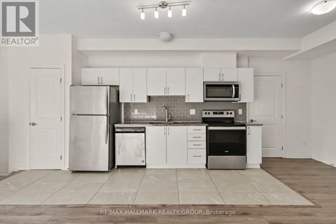 A kitchen with white cabinets and appliances is on the market with RE/MAX Hallmark Realty Group.