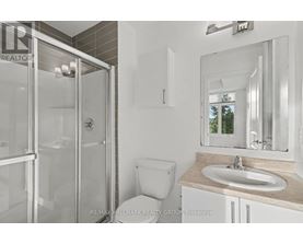A bathroom with a toilet, sink, and shower.