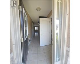 A hallway with white doors and a tiled floor.