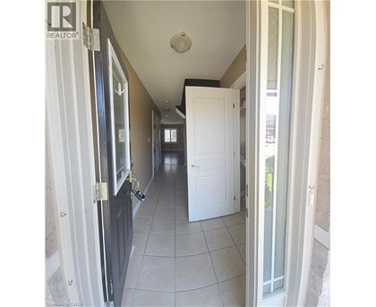 A hallway with white doors and a tiled floor.