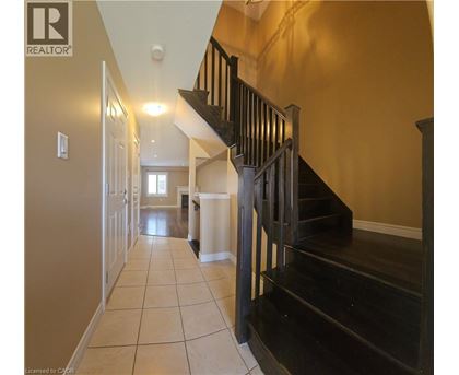 A hallway with a staircase leading to the second floor.