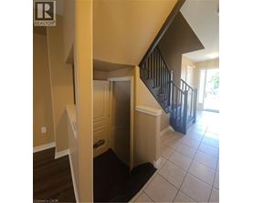 A hallway with a staircase and a door.