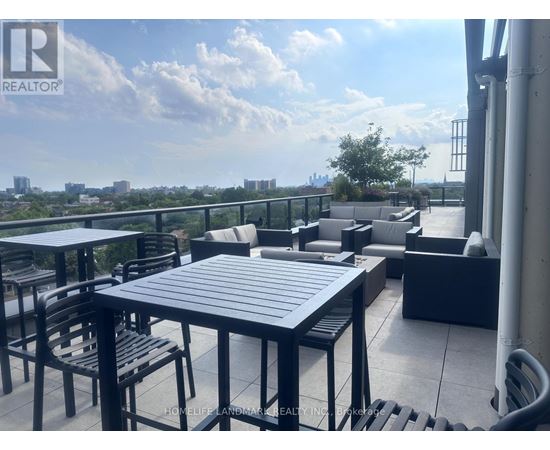 A patio with a table and chairs overlooking a cityscape.