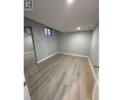A room with grey flooring and a window on the wall.