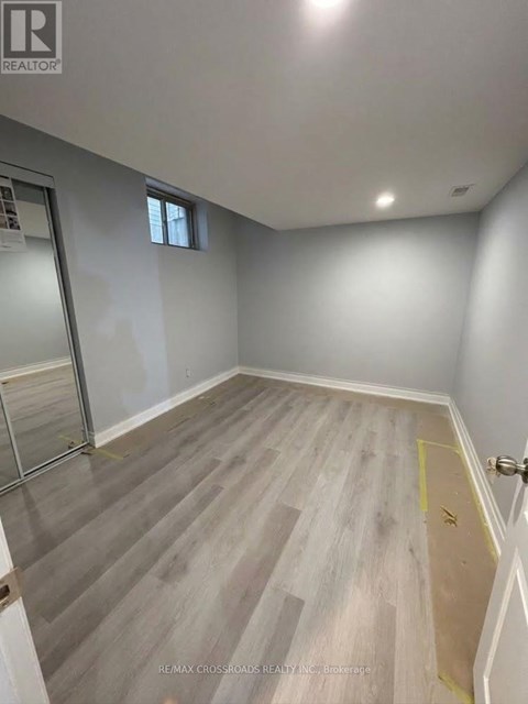 A room with grey flooring and a window on the wall.