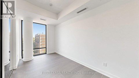 A spacious room with a view of the city through the window.