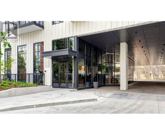 The entrance to a building with a glass door and a black railing.
