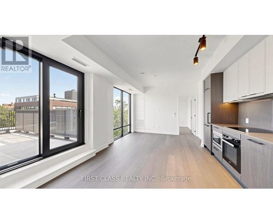 A modern kitchen with white cabinets and a wooden floor.