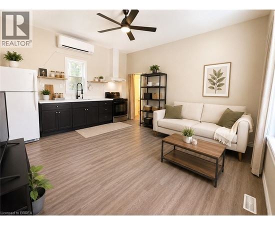 A living room with a white couch and a wooden floor.