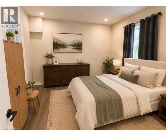 A bedroom with a bed, nightstand, and a painting on the wall.
