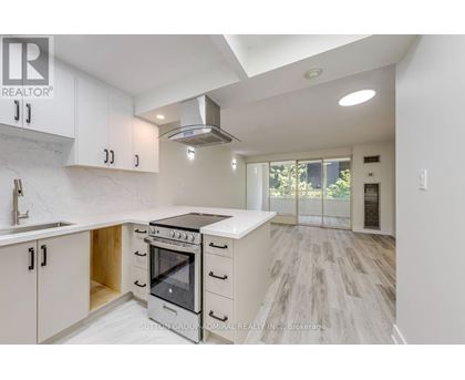 A modern kitchen with white cabinets and a black stove top oven.
