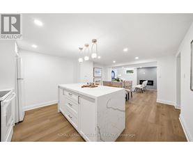 A kitchen with white cabinets and a marble island.