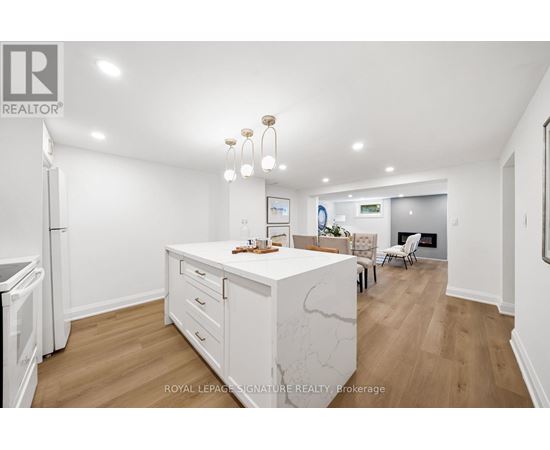 A kitchen with white cabinets and a marble island.