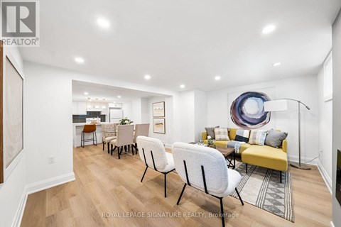 A living room with a yellow couch and a white chair.