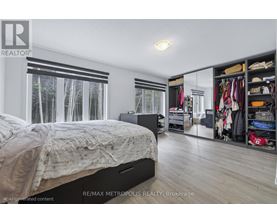 A bedroom with a large bed and a closet full of clothes.