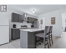 A modern kitchen with a white refrigerator and a grey island.