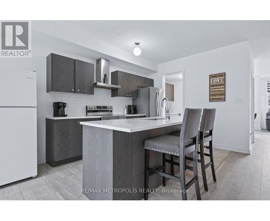 A modern kitchen with a white refrigerator and a grey island.