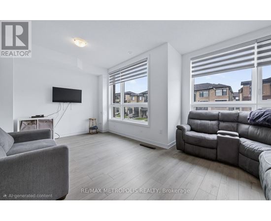 A living room with a grey couch and a flat screen TV mounted on the wall.