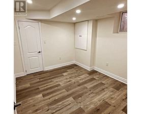 A room with a white door and a wooden floor.