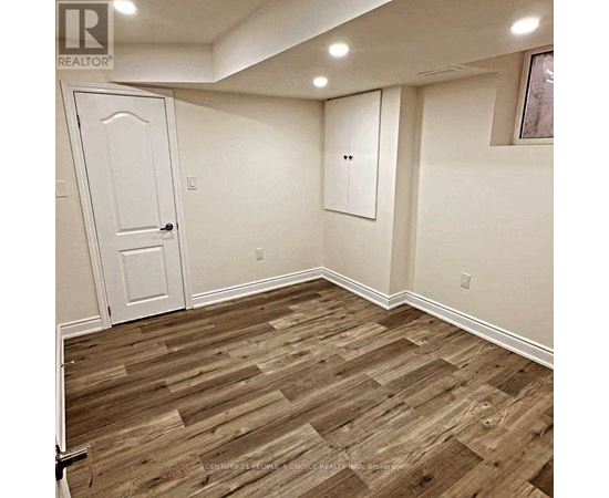 A room with a white door and a wooden floor.