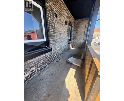 A balcony with a brick wall and wooden floor.