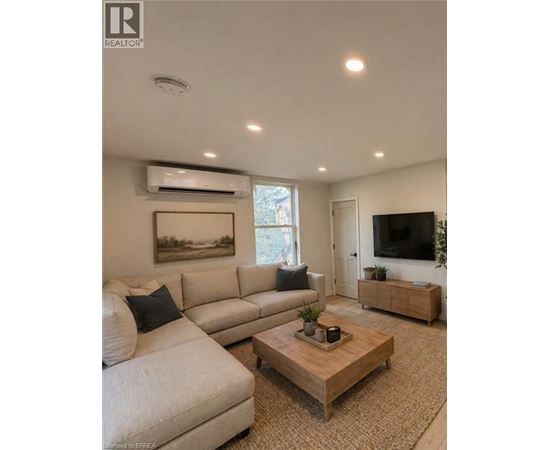 A living room with a white couch and a wooden coffee table.