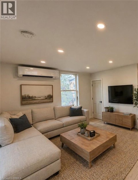 A living room with a white couch and a wooden coffee table.