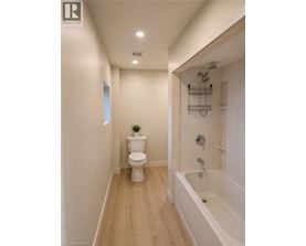 A white toilet sits in a bathroom next to a bathtub.