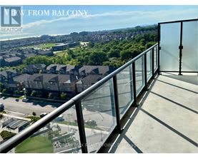 A balcony with a glass railing overlooking a residential area.