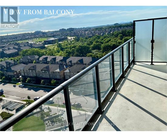 A balcony with a glass railing overlooking a residential area.