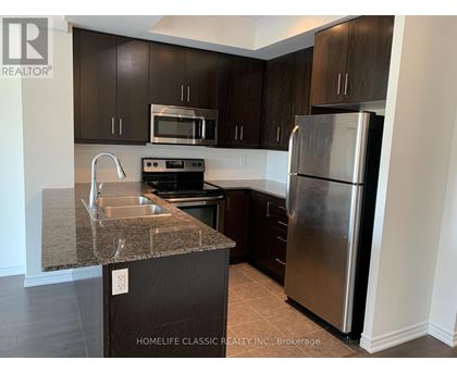 A kitchen with a granite countertop and stainless steel appliances.