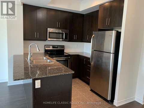 A kitchen with a granite countertop and stainless steel appliances.