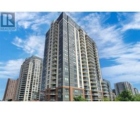 A tall residential building with a clear blue sky in the background.