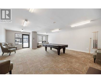 A spacious room with a long table and chairs.
