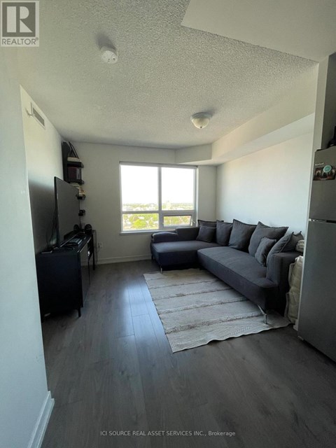 A living room with a grey couch and a television.
