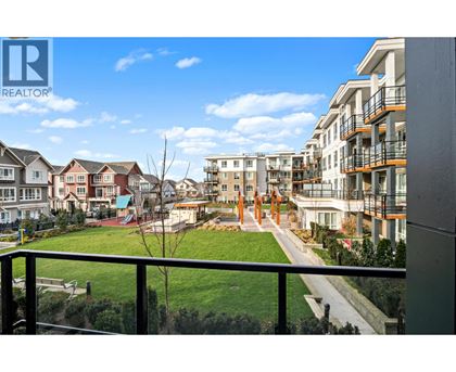 A view from a balcony overlooking a residential area with houses and apartment buildings.