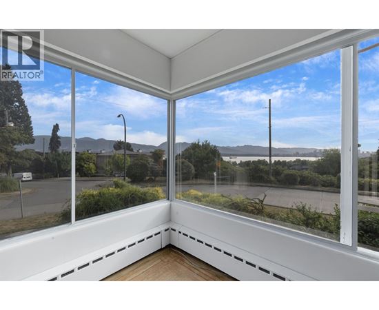 A sunny day with a view of the street and mountains from a window.