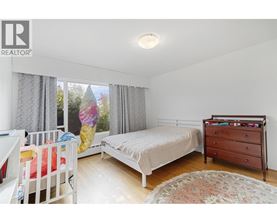 A bedroom with a white bed and a white dresser.