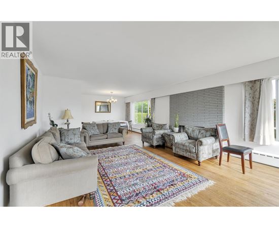 A living room with a grey couch and a rug.