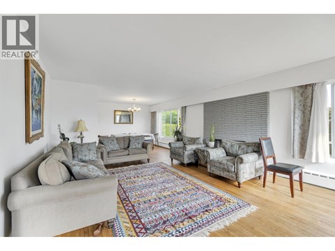 A living room with a grey couch and a rug.