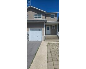 A house with a white garage door and a brown roof.