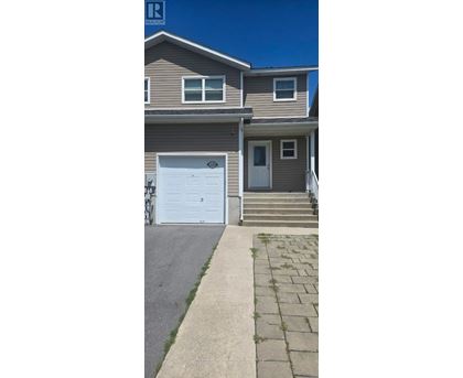 A house with a white garage door and a brown roof.