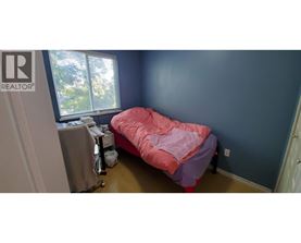 A bedroom with a bed and a desk.