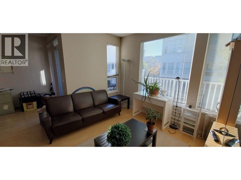 A living room with a brown couch and a sign that says REALTOR.